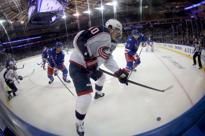 Mar 2, 2026; New York, New York, USA; Columbus Blue Jackets left wing Dmitri Voronkov (10) fights for the puck against New York Rangers defensemen Matthew Robertson (29) and Vincent Iorio (6) during the first period at Madison Square Garden. Mandatory Credit: Brad Penner-Imagn Images