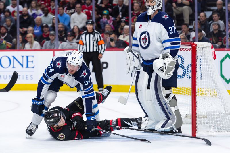 Feb 26, 2025; Ottawa, Ontario, CAN; Ottawa Senators center Ridly Greig (71) is checked by Winnipeg Jets defenseman Dylan Samberg (54) in the first period at the Canadian Tire Centre. Mandatory Credit: Marc DesRosiers-Imagn Images