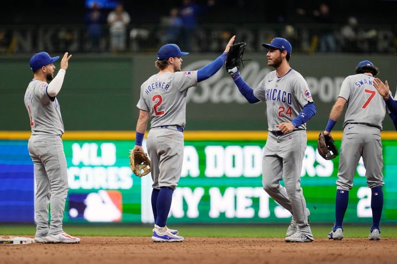 May 28, 2024; Milwaukee, Wisconsin, USA;  Chicago Cubs center fielder Cody Bellinger (24) high fives second baseman Nico Hoerner (2) followoing the game against the Milwaukee Brewers at American Family Field. Mandatory Credit: Jeff Hanisch-USA TODAY Sports