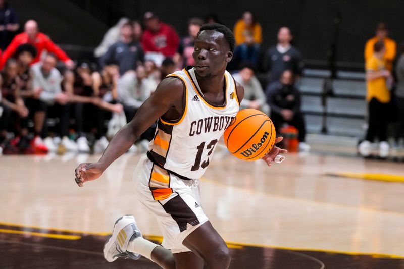 Feb 27, 2024; Laramie, Wyoming, USA; Wyoming Cowboys guard Akuel Kot (13) looks to pass against the UNLV Runnin' Rebels during the second half at Arena-Auditorium. Mandatory Credit: Troy Babbitt-USA TODAY Sports