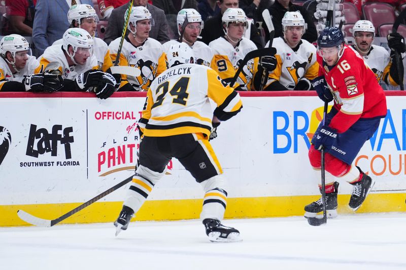 Jan 3, 2025; Sunrise, Florida, USA; Florida Panthers center Aleksander Barkov (16) passes the puck against Pittsburgh Penguins defenseman Matt Grzelcyk (24) during the first period at Amerant Bank Arena. Mandatory Credit: Rich Storry-Imagn Images