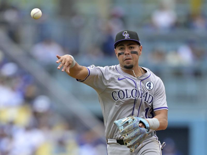 Jun 2, 2024; Los Angeles, California, USA;  Colorado Rockies second basman Alan Trejo (13) throws Los Angeles Dodgers second baseman Miguel Rojas (11) out at first in the fifth inning at Dodger Stadium. Credit: Jayne Kamin-Oncea-USA TODAY Sports