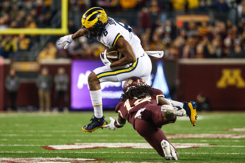 Oct 7, 2023; Minneapolis, Minnesota, USA; Michigan Wolverines wide receiver Cornelius Johnson (6) breaks a tackle by Minnesota Golden Gophers defensive back Darius Green (12) during the first quarter at Huntington Bank Stadium. Mandatory Credit: Matt Krohn-USA TODAY Sports