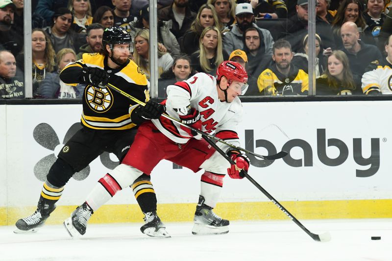 Apr 5, 2025; Boston, Massachusetts, USA; Boston Bruins center Pavel Zacha (18) hooks Carolina Hurricanes defenseman Dmitry Orlov (7) during the third period at TD Garden. Mandatory Credit: Bob DeChiara-Imagn Images