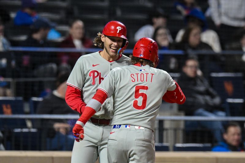 Apr 21, 2025; New York City, New York, USA; Philadelphia Phillies second baseman Bryson Stott (5) is greeted at home plate by catcher J.T. Realmuto (10) after hitting a three run home run against the New York Mets during the ninth inning at Citi Field. Mandatory Credit: John Jones-Imagn Images