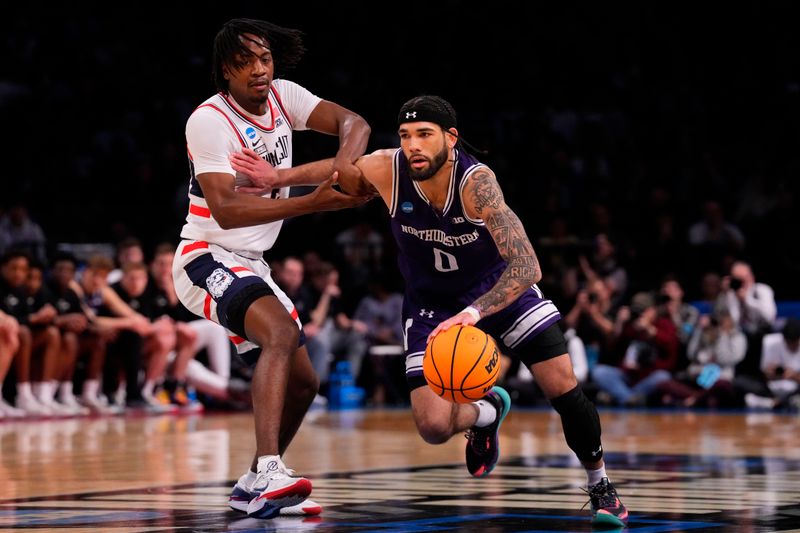 Mar 24, 2024; Brooklyn, NY, USA; Northwestern Wildcats guard Boo Buie (0) dribbles the ball past Connecticut Huskies guard Tristen Newton (2) in the second round of the 2024 NCAA Tournament at the Barclays Center. Mandatory Credit: Robert Deutsch-USA TODAY Sports