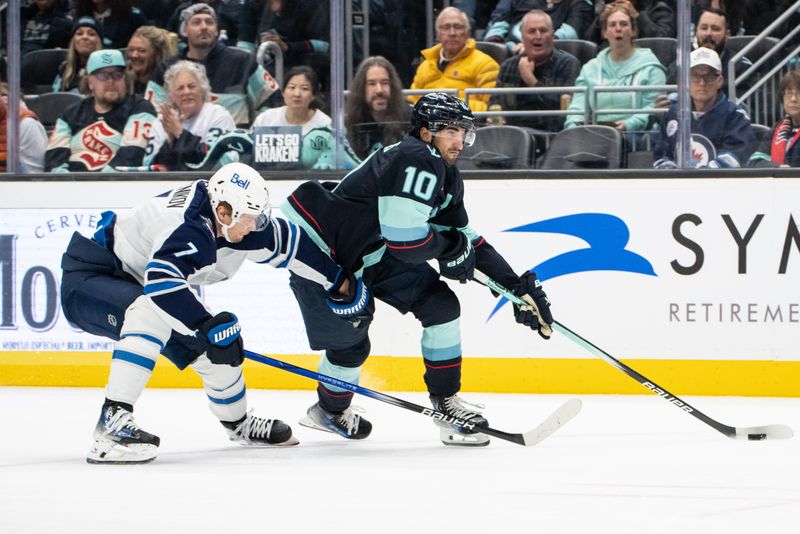 Oct 24, 2024; Seattle, Washington, USA;  Seattle Kraken forward Matty Beniers (10) skates against Winnipeg Jets forward Vladislav Namestnikov (7) during the third period at Climate Pledge Arena. Mandatory Credit: Stephen Brashear-Imagn Images