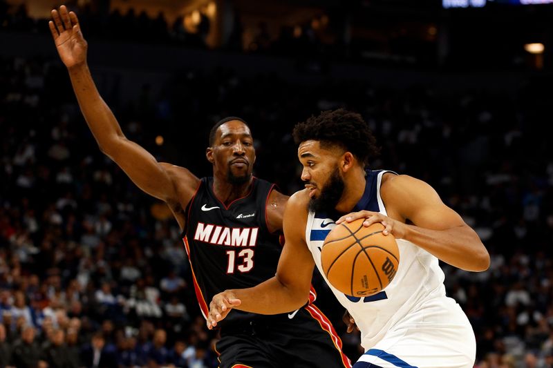 MINNEAPOLIS, MINNESOTA - OCTOBER 28: Karl-Anthony Towns #32 of the Minnesota Timberwolves drives to the basket while Bam Adebayo #13 of the Miami Heat defends in the third quarter at Target Center on October 28, 2023 in Minneapolis, Minnesota. The Timberwolves defeated the Heat 106-90. NOTE TO USER: User expressly acknowledges and agrees that, by downloading and or using this photograph, User is consenting to the terms and conditions of the Getty Images License Agreement. (Photo by David Berding/Getty Images)