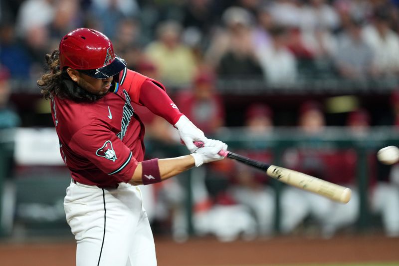 Apr 2, 2024; Phoenix, Arizona, USA; Arizona Diamondbacks third baseman Eugenio Suarez (28) hits a single against the New York Yankees during the first inning at Chase Field. Mandatory Credit: Joe Camporeale-USA TODAY Sports