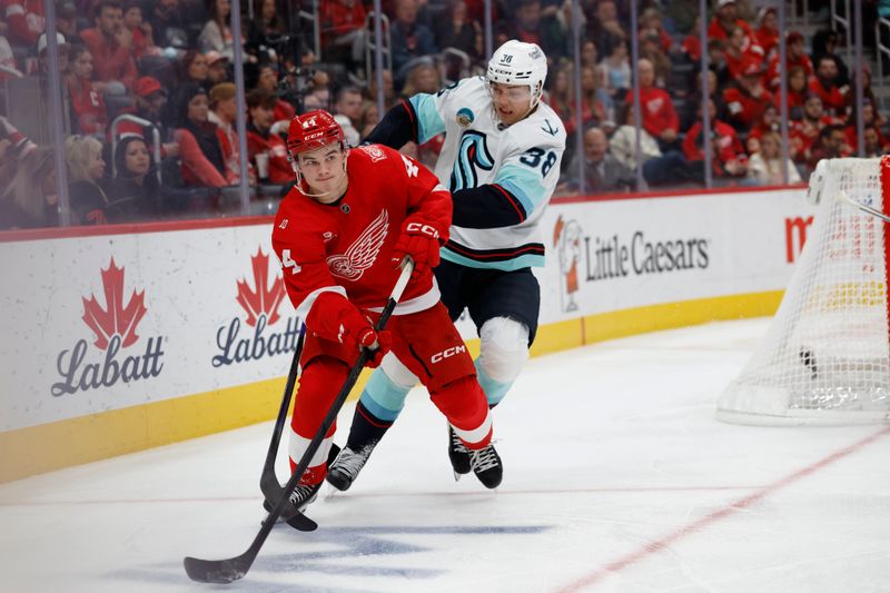 Nov 18, 2025; Detroit, Michigan, USA; Detroit Red Wings defenseman Axel Sandin-Pellikka (44) plays the puck defended by Seattle Kraken right wing Jani Nyman (38) in the third period at Little Caesars Arena. Mandatory Credit: Rick Osentoski-Imagn Images