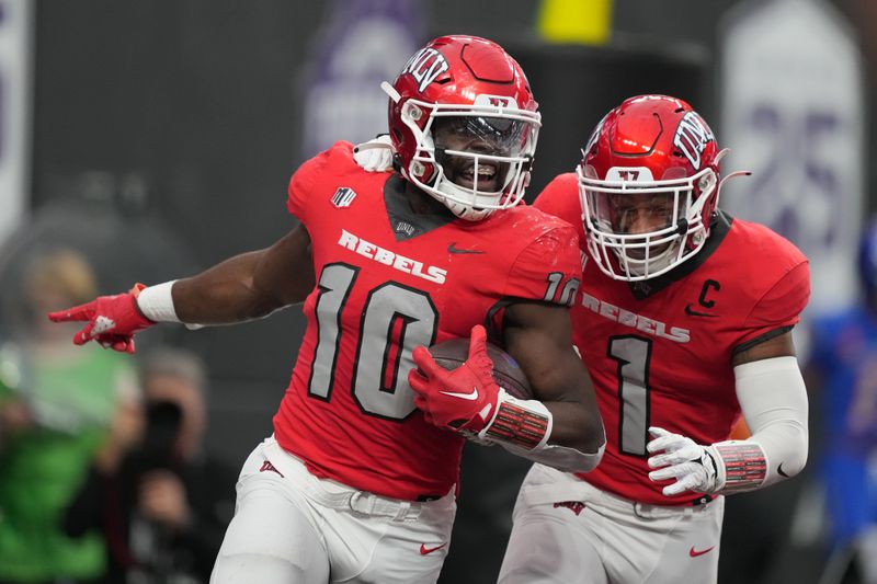 Dec 2, 2023; Las Vegas, NV, USA; UNLV Rebels linebacker Fred Thompkins (10) celebrates with defensive back Jerrae Williams (1) after intercepting a pass for a touchdown against the Boise State Broncos in the first half during the Mountain West Championship at Allegiant Stadium. Mandatory Credit: Kirby Lee-USA TODAY Sports