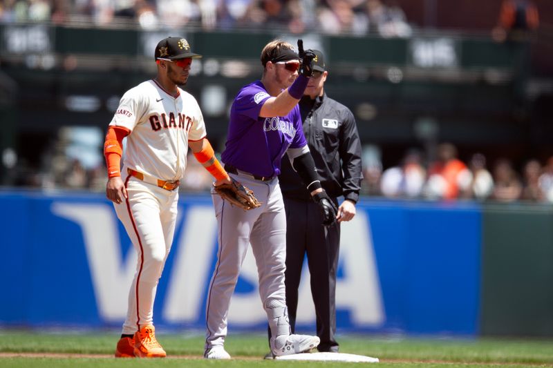 May 18, 2024; San Francisco, California, USA; Colorado Rockies catcher Hunter Goodman (15) stands next to  San Francisco Giants second baseman Thairo Estrada (39) and gestures back to his dugout after hitting a double during the third inning at Oracle Park. Mandatory Credit: D. Ross Cameron-USA TODAY Sports