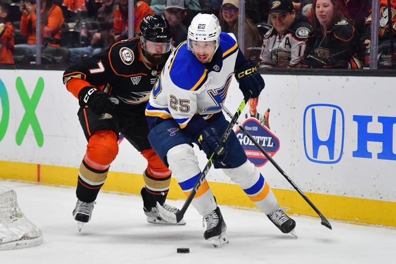 Apr 7, 2024; Anaheim, California, USA; St. Louis Blues center Jordan Kyrou (25) moves the puck ahead of Anaheim Ducks defenseman Radko Gudas (7) during the third period at Honda Center. Mandatory Credit: Gary A. Vasquez-USA TODAY Sports