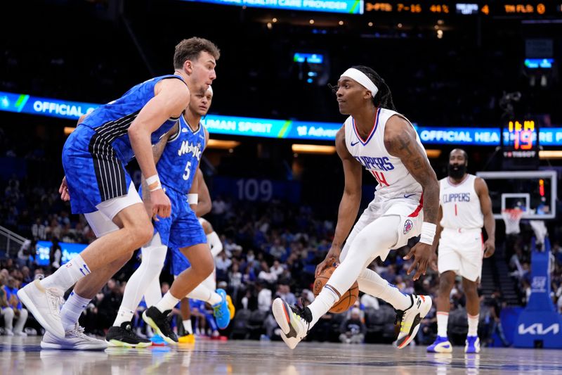 ORLANDO, FLORIDA - MARCH 29: Terance Mann #14 of the LA Clippers dribbles the ball against Franz Wagner #22 of the Orlando Magic during the third quarter at Kia Center on March 29, 2024 in Orlando, Florida. NOTE TO USER: User expressly acknowledges and agrees that, by downloading and or using this photograph, User is consenting to the terms and conditions of the Getty Images License Agreement. (Photo by Rich Storry/Getty Images)