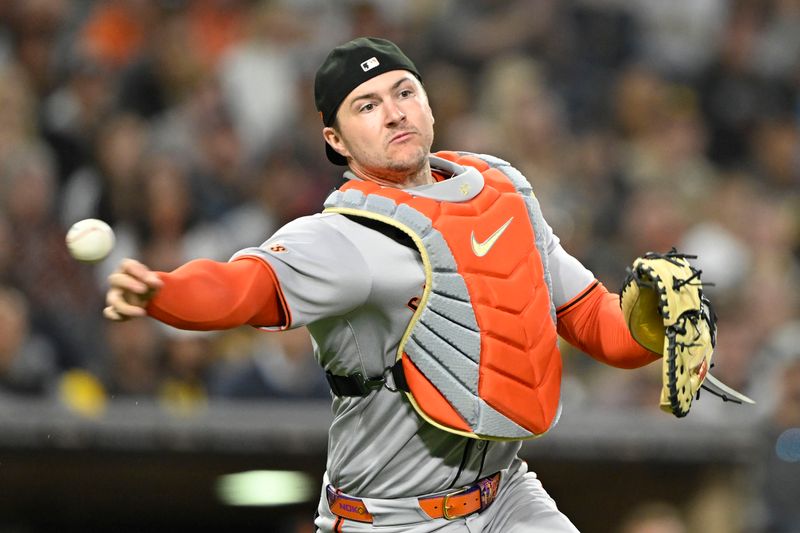 Apr 29, 2025; San Diego, California, USA; San Francisco Giants catcher Patrick Bailey (14) throws San Diego Padres right fielder Fernando Tatis Jr. (23) out at first base during the fourth inning at Petco Park. Mandatory Credit: Denis Poroy-Imagn Images