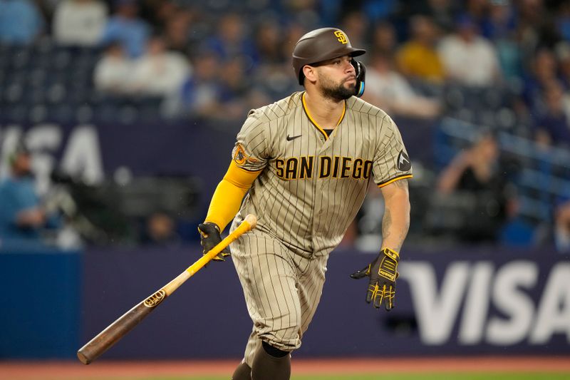 Jul 18, 2023; Toronto, Ontario, CAN;  San Diego Padres catcher Gary Sanchez (99) hits an RBI sacrifice fly ball against the Toronto Blue Jays during the ninth inning at Rogers Centre. Mandatory Credit: John E. Sokolowski-USA TODAY Sports