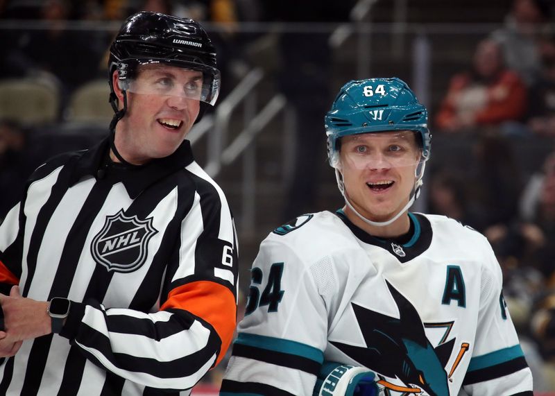 Nov 16, 2024; Pittsburgh, Pennsylvania, USA;  NHl referee Francis Charron (6) and San Jose Sharks center Mikael Granlund (64) talk on the ice against the Pittsburgh Penguins during the third period at PPG Paints Arena. Mandatory Credit: Charles LeClaire-Imagn Images