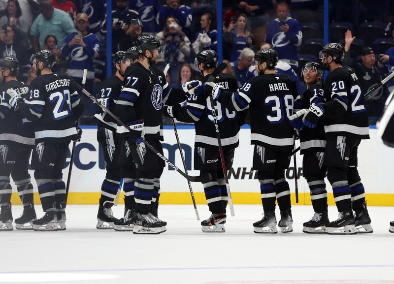 Oct 26, 2024; Tampa, Florida, USA; Tampa Bay Lightning defenseman Victor Hedman (77), defenseman J.J. Moser (90), left wing Brandon Hagel (38) and teammates celebrate after defeating the Washington Capitals at Amalie Arena. Mandatory Credit: Kim Klement Neitzel-Imagn Images