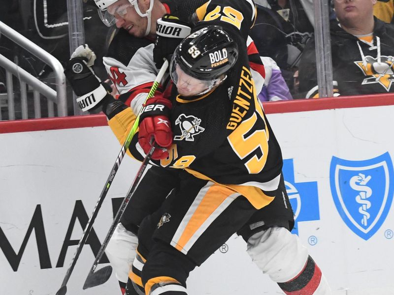 Nov 16, 2023; Pittsburgh, Pennsylvania, USA; Pittsburgh Penguins left wing Jake Guentzel (59) and New Jersey Devils right wing Nathan Bastian (14) battle for the puck during the second period at PPG Paints Arena. Mandatory Credit: Philip G. Pavely-USA TODAY Sports