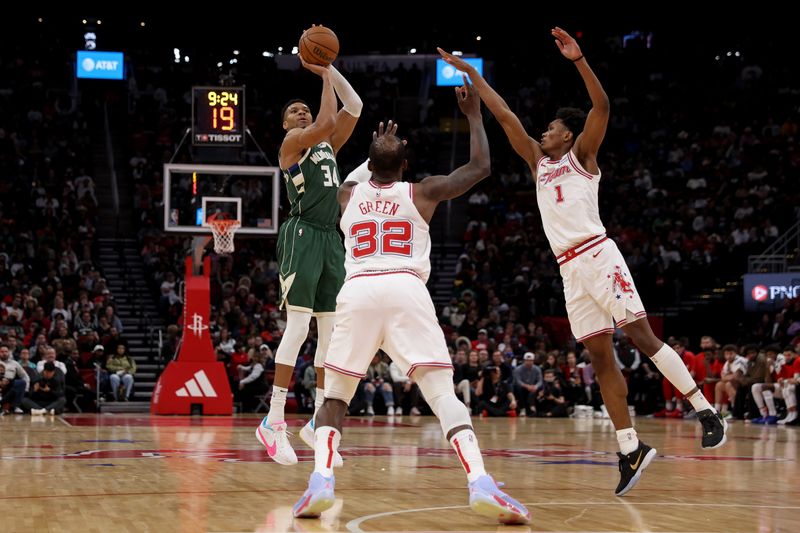 HOUSTON, TEXAS - JANUARY 06: Giannis Antetokounmpo #34 of the Milwaukee Bucks shoots a three-point shot while defended by Amen Thompson #1 and Jeff Green #32 of the Houston Rockets in the second half at Toyota Center on January 06, 2024 in Houston, Texas.  NOTE TO USER: User expressly acknowledges and agrees that, by downloading and or using this photograph, User is consenting to the terms and conditions of the Getty Images License Agreement. (Photo by Tim Warner/Getty Images)