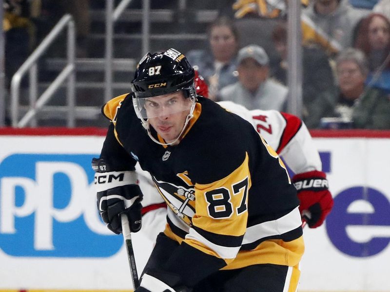 Oct 18, 2024; Pittsburgh, Pennsylvania, USA;  Pittsburgh Penguins center Sidney Crosby (87) skates up ice with the puck against the Carolina Hurricanes during the third period at PPG Paints Arena. Mandatory Credit: Charles LeClaire-Imagn Images