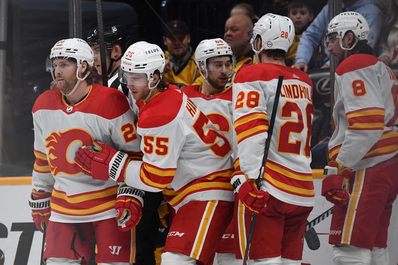 Jan 4, 2024; Nashville, Tennessee, USA; Calgary Flames defenseman Noah Hanifin (55) celebrates with teammates after a goal during the second period against the Nashville Predators at Bridgestone Arena. Mandatory Credit: Christopher Hanewinckel-USA TODAY Sports