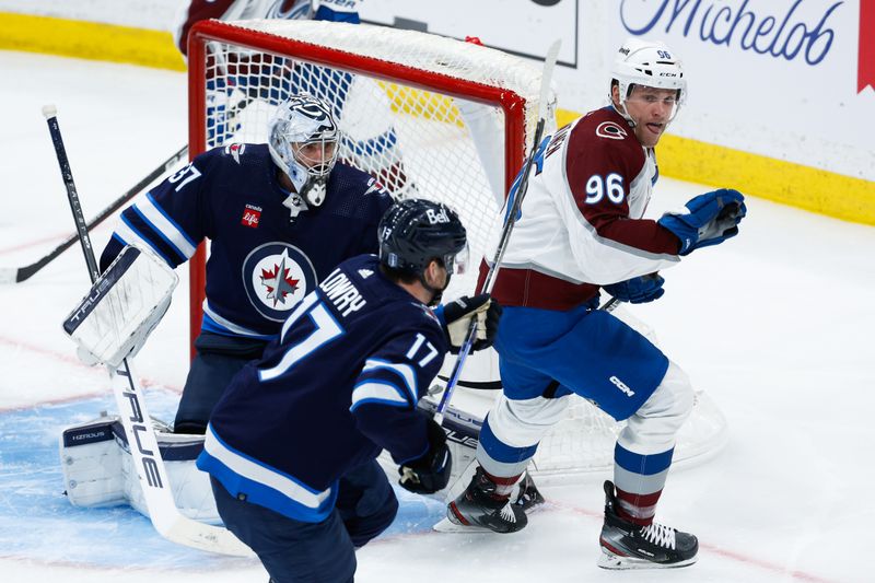 Apr 23, 2024; Winnipeg, Manitoba, CAN; Colorado Avalanche forward Mikko Rantanen (96) and Winnipeg Jets goalie Connor Hellebuyck (37) look for the puck during the third period in game two of the first round of the 2024 Stanley Cup Playoffs at Canada Life Centre. Mandatory Credit: Terrence Lee-USA TODAY Sports