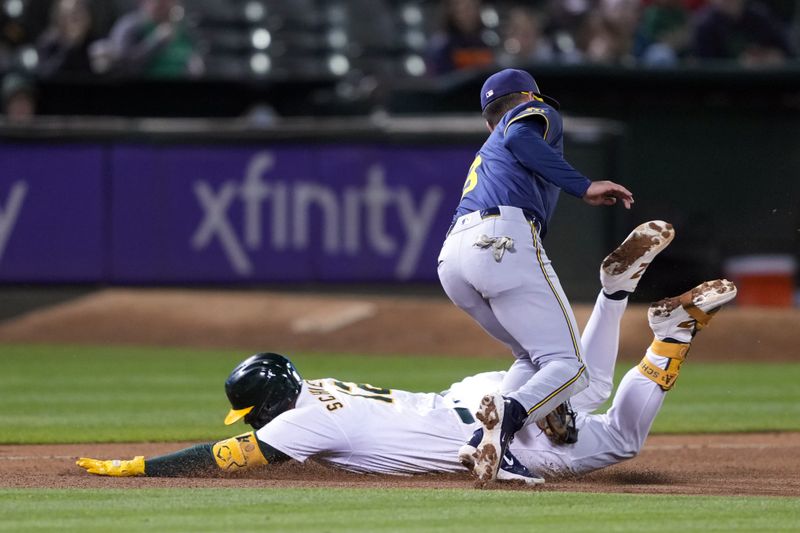 Aug 23, 2024; Oakland, California, USA; Milwaukee Brewers third baseman Joey Ortiz (right) tags out Oakland Athletics shortstop Max Schuemann (left) during the seventh inning at Oakland-Alameda County Coliseum. Mandatory Credit: Darren Yamashita-USA TODAY Sports