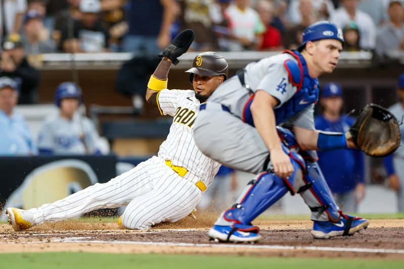 Jul 30, 2024; San Diego, California, USA; San Diego Padres designated hitter Luis Arraez (4) slides past Los Angeles Dodgers catcher Will Smith (16) to score a run during the third inning against the Los Angeles Dodgers at Petco Park. Mandatory Credit: David Frerker-USA TODAY Sports