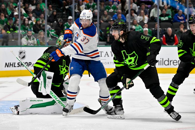 Apr 3, 2024; Dallas, Texas, USA; Edmonton Oilers left wing Warren Foegele (37) attempts to redirect the puck past Dallas Stars defenseman Chris Tanev (3) and goaltender Jake Oettinger (29) during the third period at the American Airlines Center. Mandatory Credit: Jerome Miron-USA TODAY Sports
