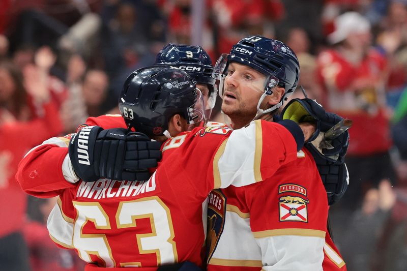 Dec 20, 2025; Sunrise, Florida, USA; Florida Panthers center Sam Reinhart (13) celebrates with left wing Brad Marchand (63) and center Sam Bennett (9) after scoring against the St. Louis Blues during the second period at Amerant Bank Arena. Mandatory Credit: Sam Navarro-Imagn Images
