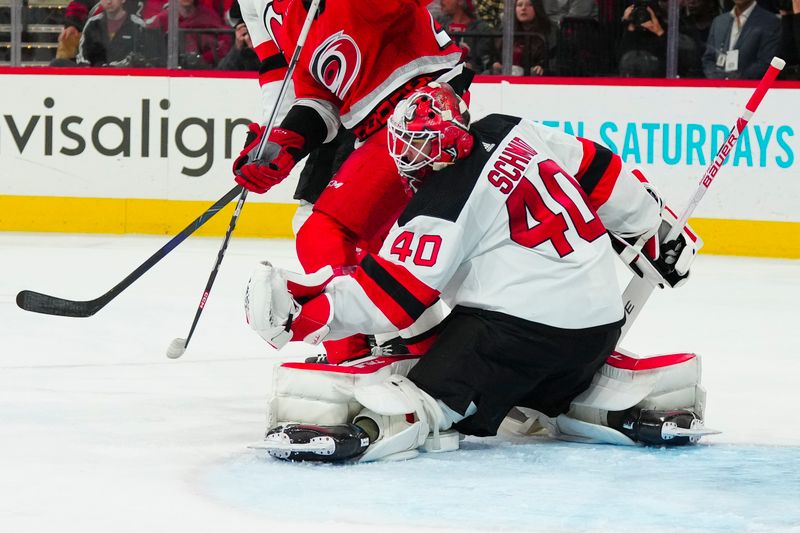 May 11, 2023; Raleigh, North Carolina, USA; New Jersey Devils goaltender Akira Schmid (40) makes a glove save against the Carolina Hurricanes during the third period in game five of the second round of the 2023 Stanley Cup Playoffs at PNC Arena. Mandatory Credit: James Guillory-USA TODAY Sports