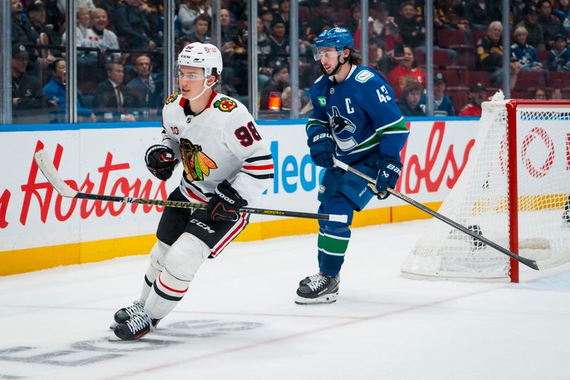 Nov 5, 2025; Vancouver, British Columbia, CAN; Vancouver Canucks defenseman Quinn Hughes (43) reacts as Chicago Blackhawks forward Connor Bedard (98) scores an empty net goal in the third period at Rogers Arena. Mandatory Credit: Bob Frid-Imagn Images