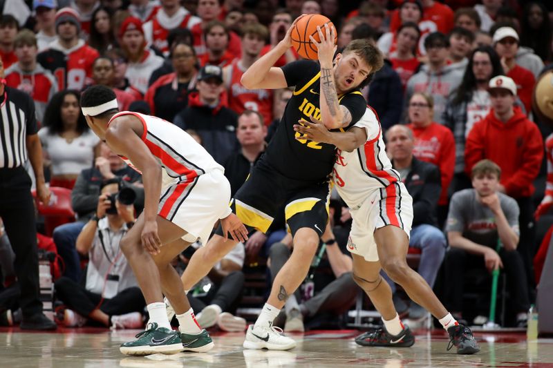 Jan 27, 2025; Columbus, Ohio, USA;  Iowa Hawkeyes forward Owen Freeman (32) takes the hard foul from Ohio State Buckeyes forward Sean Stewart (13) during the second half at Value City Arena. Mandatory Credit: Joseph Maiorana-Imagn Images