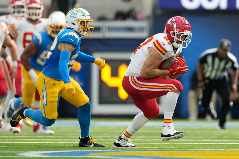 Kansas City Chiefs tight end Travis Kelce catches a pass as Los Angeles Chargers defensive back Elijah Molden (22) defends during the first half of an NFL football game Sunday, Sept. 29, 2024, in Inglewood, Calif. (AP Photo/Ashley Landis)