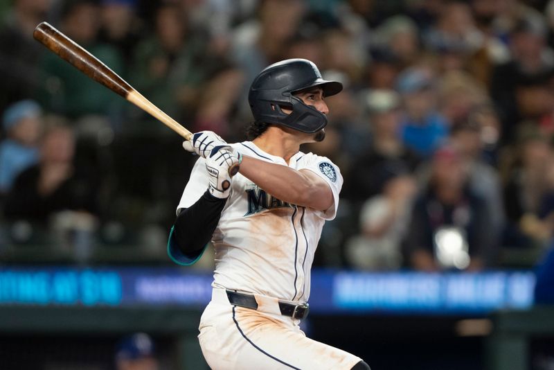 Jun 15, 2024; Seattle, Washington, USA; Seattle Mariners third baseman Josh Rojas (4) hits a solo home run during the seventh inning against the Texas Rangers at T-Mobile Park. Mandatory Credit: Stephen Brashear-USA TODAY Sports