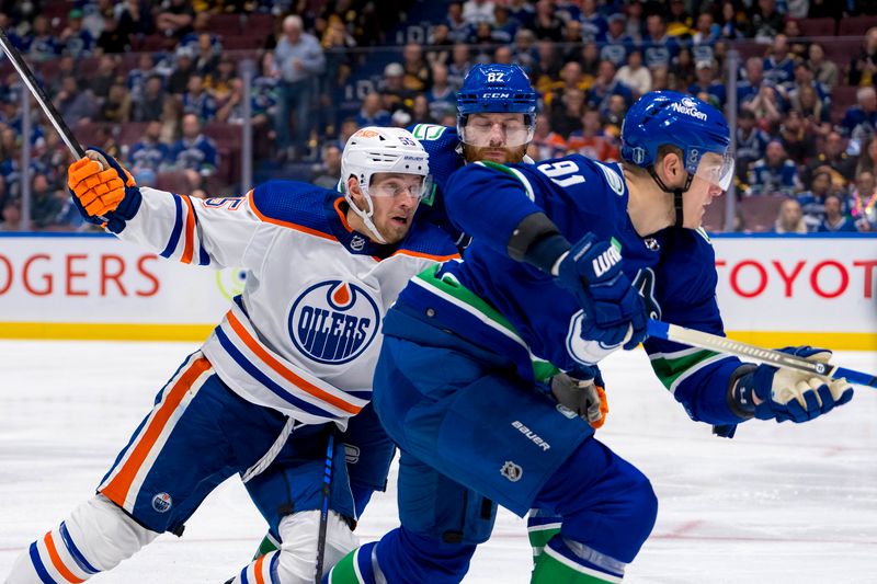 May 20, 2024; Vancouver, British Columbia, CAN; Edmonton Oilers forward Dylan Holloway (55) battles with Vancouver Canucks defenseman Ian Cole (82) and defenseman Nikita Zadorov (91) during the second period in game seven of the second round of the 2024 Stanley Cup Playoffs at Rogers Arena. Mandatory Credit: Bob Frid-USA TODAY Sports