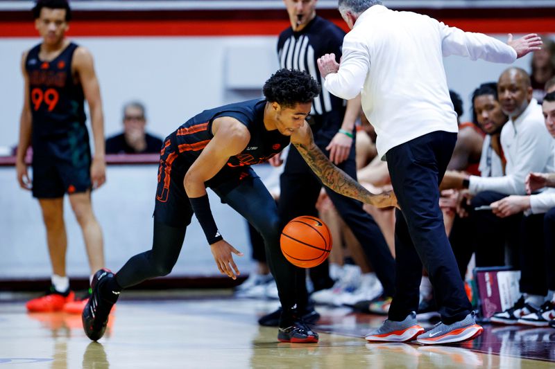 Jan 4, 2025; Blacksburg, Virginia, USA; Virginia Tech Hokies head coach Mike Young interferes with loose ball on the court while Miami Hurricanes guard Jalil Bethea (3) goes for the ball during the first half at Cassell Coliseum. Mandatory Credit: Peter Casey-Imagn Images