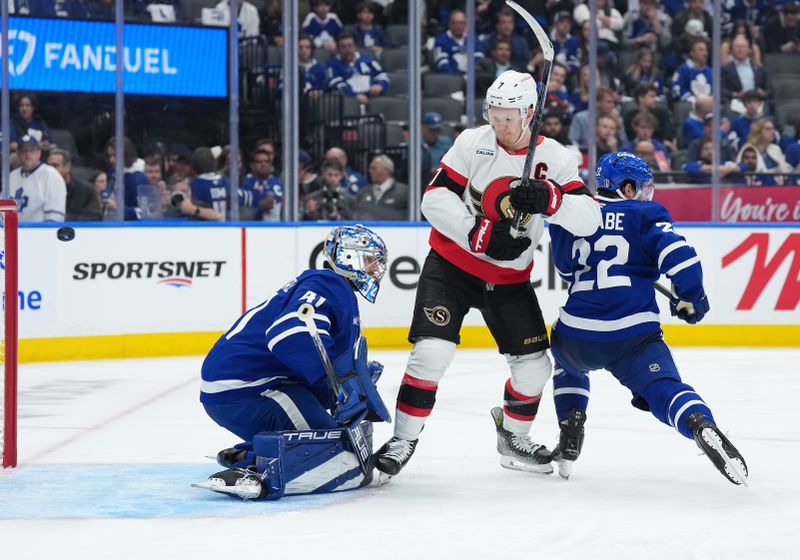 Apr 29, 2025; Toronto, Ontario, CAN; Toronto Maple Leafs defenseman Jake McCabe (22) battles for the puck with Ottawa Senators left wing Brady Tkachuk (7) as the puck goes into the net for a goal by defenseman Thomas Chabot (not pictured) in the second period during game five of the first round of the 2025 Stanley Cup Playoffs at Scotiabank Arena. Mandatory Credit: Nick Turchiaro-Imagn Images