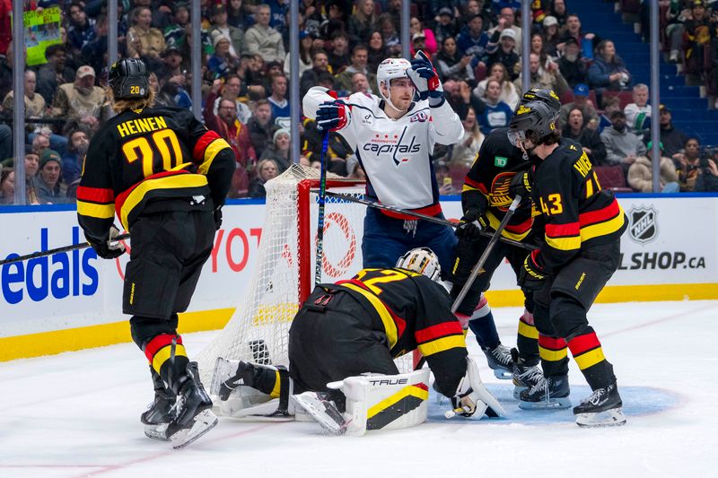 Jan 25, 2025; Vancouver, British Columbia, CAN; Vancouver Canucks forward Danton Heinen (20) and defenseman Quinn Hughes (43) and defenseman Filip Hronek (17) watch as Washington Capitals forward Pierre-Luc Dubois (80) celebrates his goal scored on goalie Kevin Lankinen (32) in the third period at Rogers Arena. Mandatory Credit: Bob Frid-Imagn Images