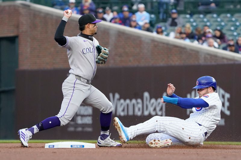 May 28, 2025; Chicago, Illinois, USA; Colorado Rockies shortstop Ezequiel Tovar (14) forces out Chicago Cubs outfielder Ian Happ (8) at second base during the first inning at Wrigley Field. Mandatory Credit: David Banks-Imagn Images