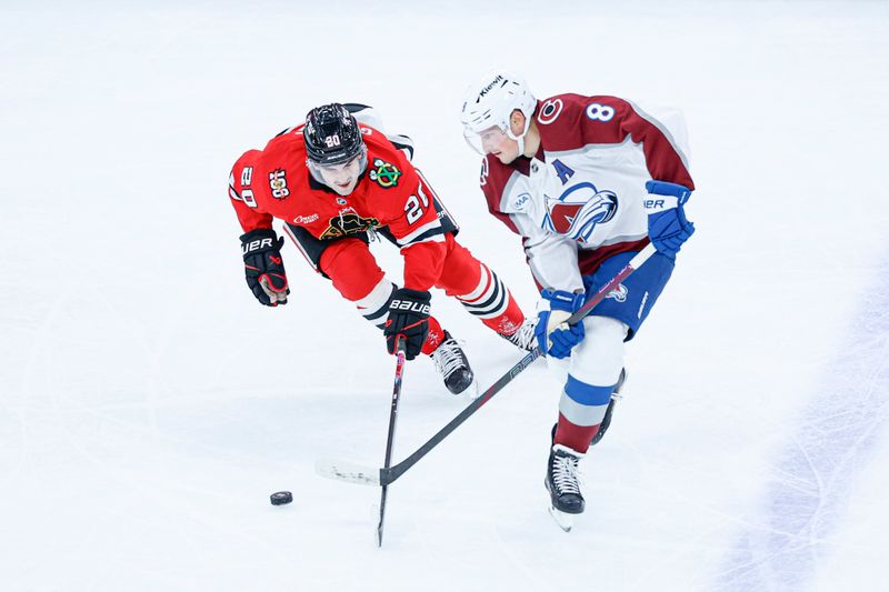 Nov 23, 2025; Chicago, Illinois, USA; Chicago Blackhawks center Ryan Greene (20) battles for the puck with Colorado Avalanche defenseman Cale Makar (8) during the second period at United Center. Mandatory Credit: Kamil Krzaczynski-Imagn Images