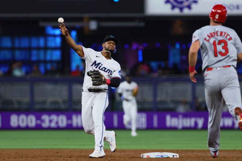 Jun 19, 2024; Miami, Florida, USA; Miami Marlins second baseman Otto Lopez (61) forces out St. Louis Cardinals designated hitter Matt Carpenter (13) at second base during the second inning at loanDepot Park. Mandatory Credit: Sam Navarro-USA TODAY Sports