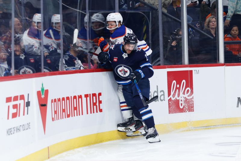 Sep 25, 2024; Winnipeg, Manitoba, CAN; Winnipeg Jets defenseman Dylan DeMelo (2) bodies Edmonton Oilers forward Mattias Janmark (13) during the first period at Canada Life Centre. Mandatory Credit: Terrence Lee-Imagn Images