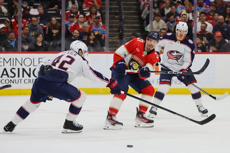 Apr 11, 2024; Sunrise, Florida, USA; Florida Panthers center Nick Cousins (21) moves the puck against the Columbus Blue Jackets during the second period at Amerant Bank Arena. Mandatory Credit: Sam Navarro-USA TODAY Sports