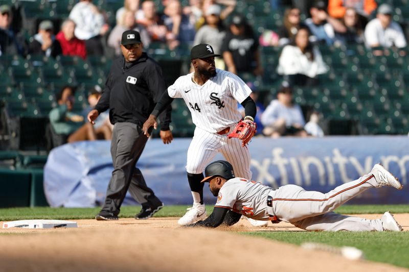 May 26, 2024; Chicago, Illinois, USA; Baltimore Orioles outfielder Cedric Mullins (31) advances to third base against Chicago White Sox third baseman Bryan Ramos (44) during the ninth inning at Guaranteed Rate Field. Mandatory Credit: Kamil Krzaczynski-USA TODAY Sports