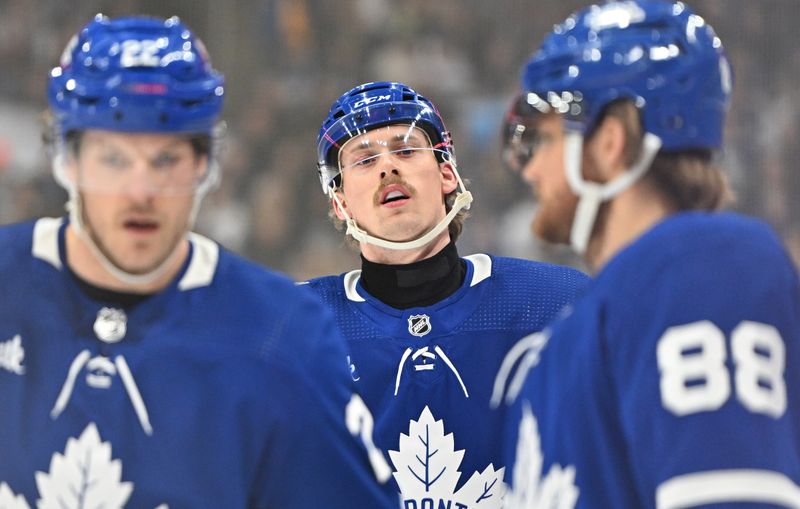 Dec 30, 2023; Toronto, Ontario, CAN; Toronto Maple Leafs defenseman Simon Benoit (2) looks on as forward William Nylander (88) speaks to defenseman Jake McCabe (22) in the first period against the Carolina Hurricanes at Scotiabank Arena. Mandatory Credit: Dan Hamilton-USA TODAY Sports