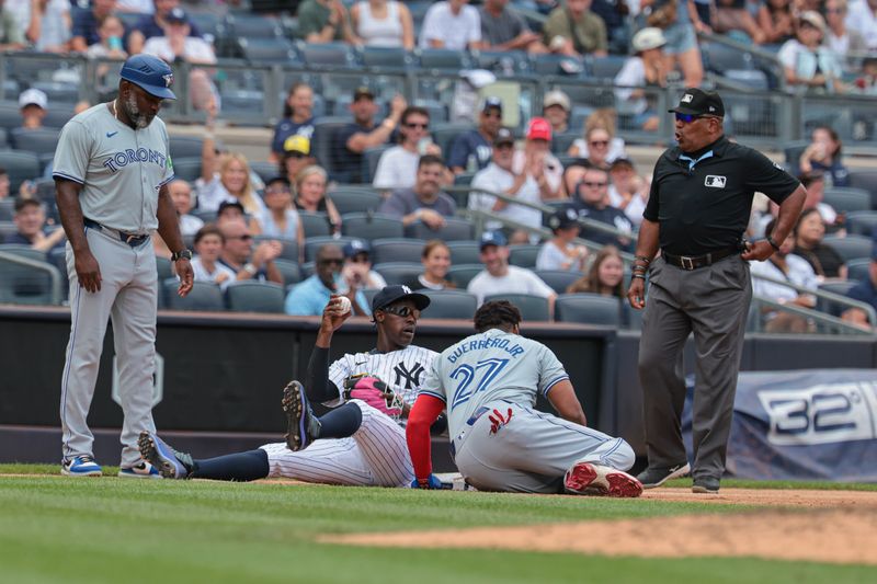 Aug 4, 2024; Bronx, New York, USA;  New York Yankees third baseman Jazz Chisholm Jr. (13) tags out Toronto Blue Jays first baseman Vladimir Guerrero Jr. (27) on a steal attempt at third base during the third inning at Yankee Stadium. Mandatory Credit: Vincent Carchietta-USA TODAY Sports