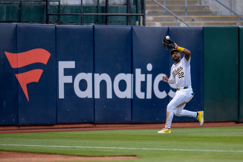 Aug 20, 2024; Oakland, California, USA; Oakland Athletics left fielder Miguel Andujar (22) fields a fly ball against the Tampa Bay Rays during the fourth inning at Oakland-Alameda County Coliseum. Mandatory Credit: Neville E. Guard-USA TODAY Sports