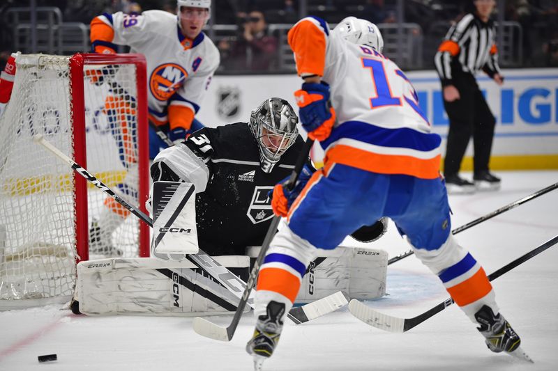 Mar 11, 2024; Los Angeles, California, USA; Los Angeles Kings goaltender David Rittich (31) blocks a shot against New York Islanders center Mathew Barzal (13) during the first period at Crypto.com Arena. Mandatory Credit: Gary A. Vasquez-USA TODAY Sports